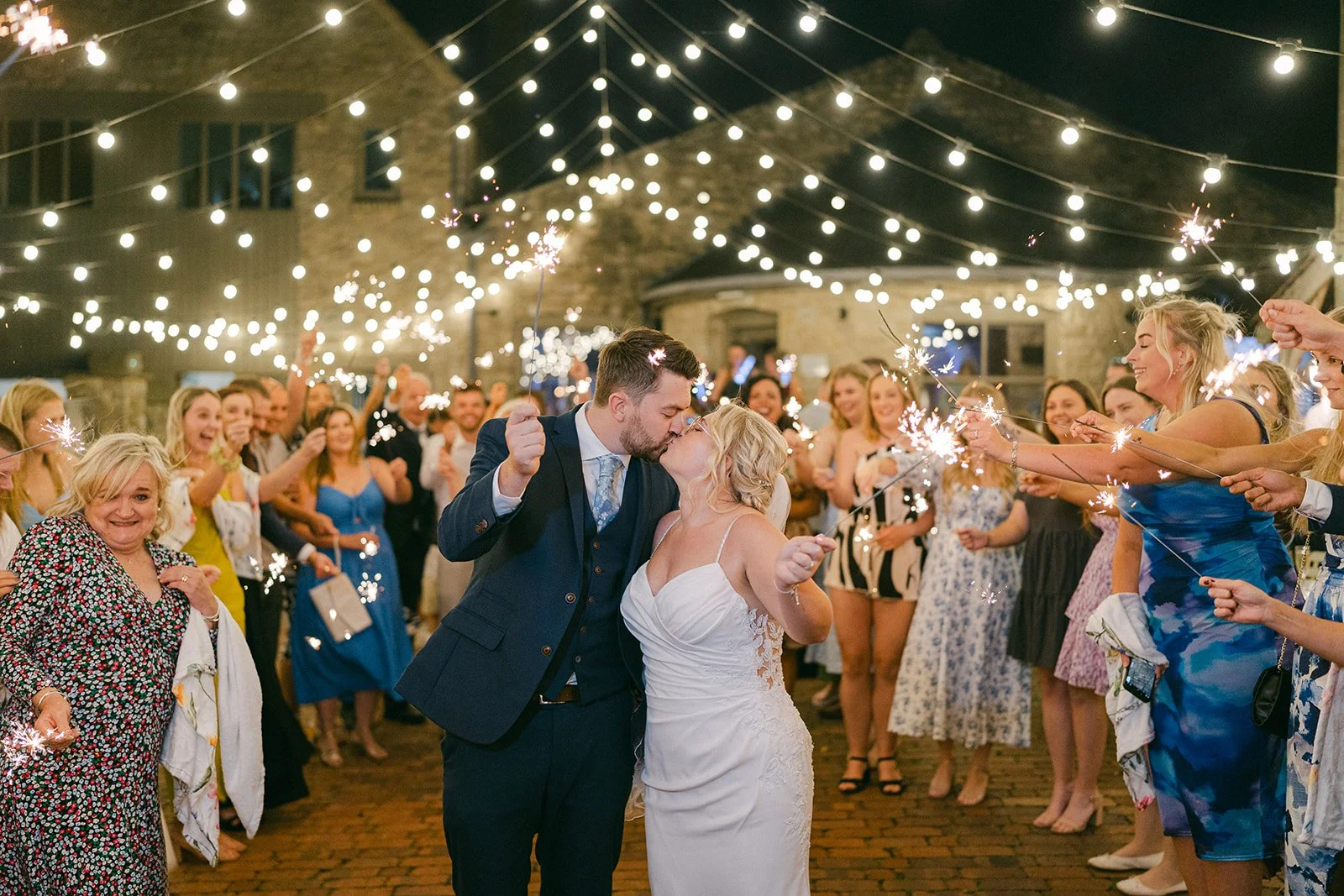 Bride and groom walking holding hands  through stone courtyard