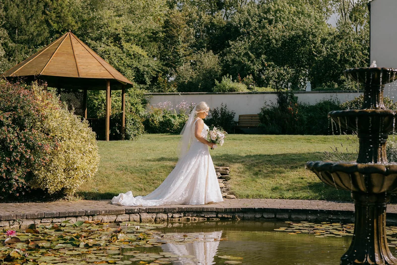 Bride walking through garden in her wedding dress