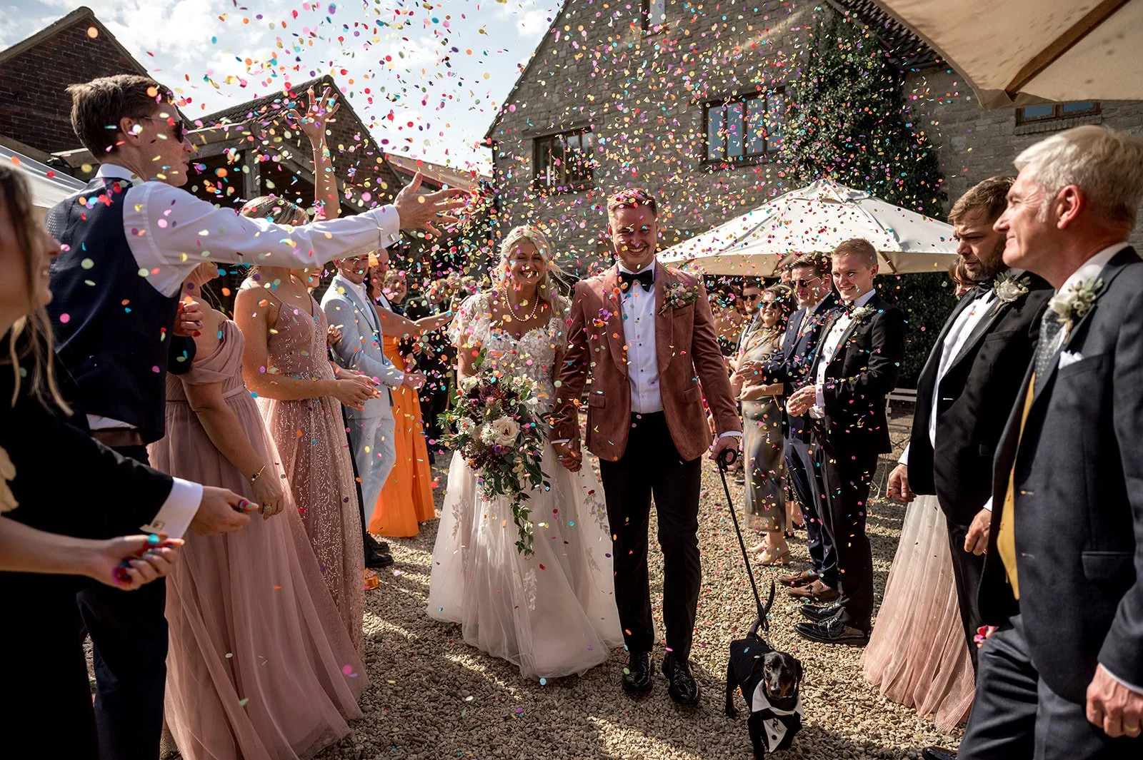 newlywed couple walking down the aisle with guests cheering