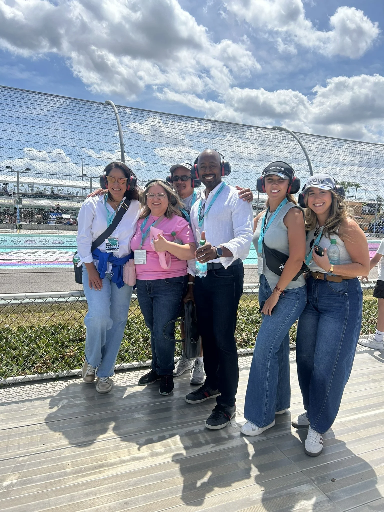 Group wearing hearing protection beside the track fence at Homestead-Miami Speedway.