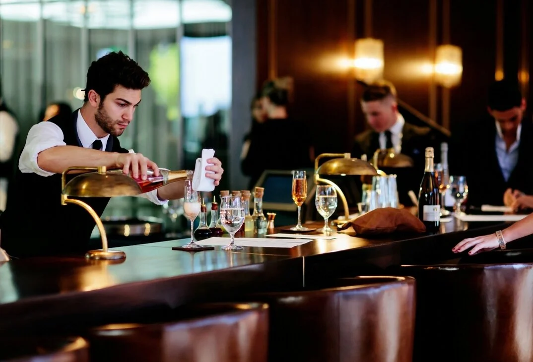 bartender pouring glass of wine