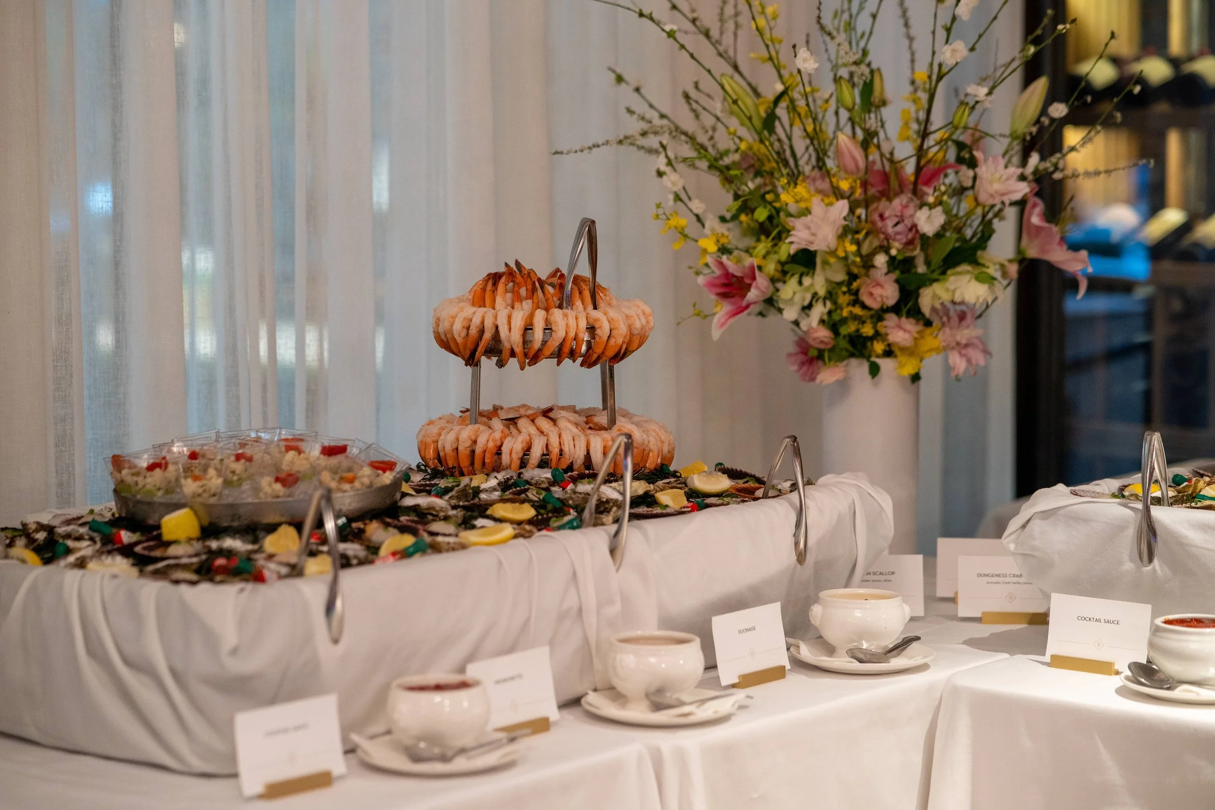 decadent shrimp-cocktail tower on top of a table of fresh scallops and oysters