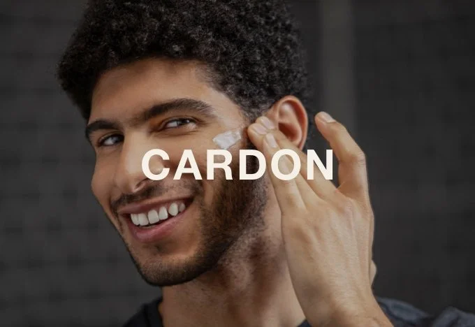 A young man with dark curly hair is smiling as he applies a bandage to his ear, with the word 'CARDON' overlaid on the image.