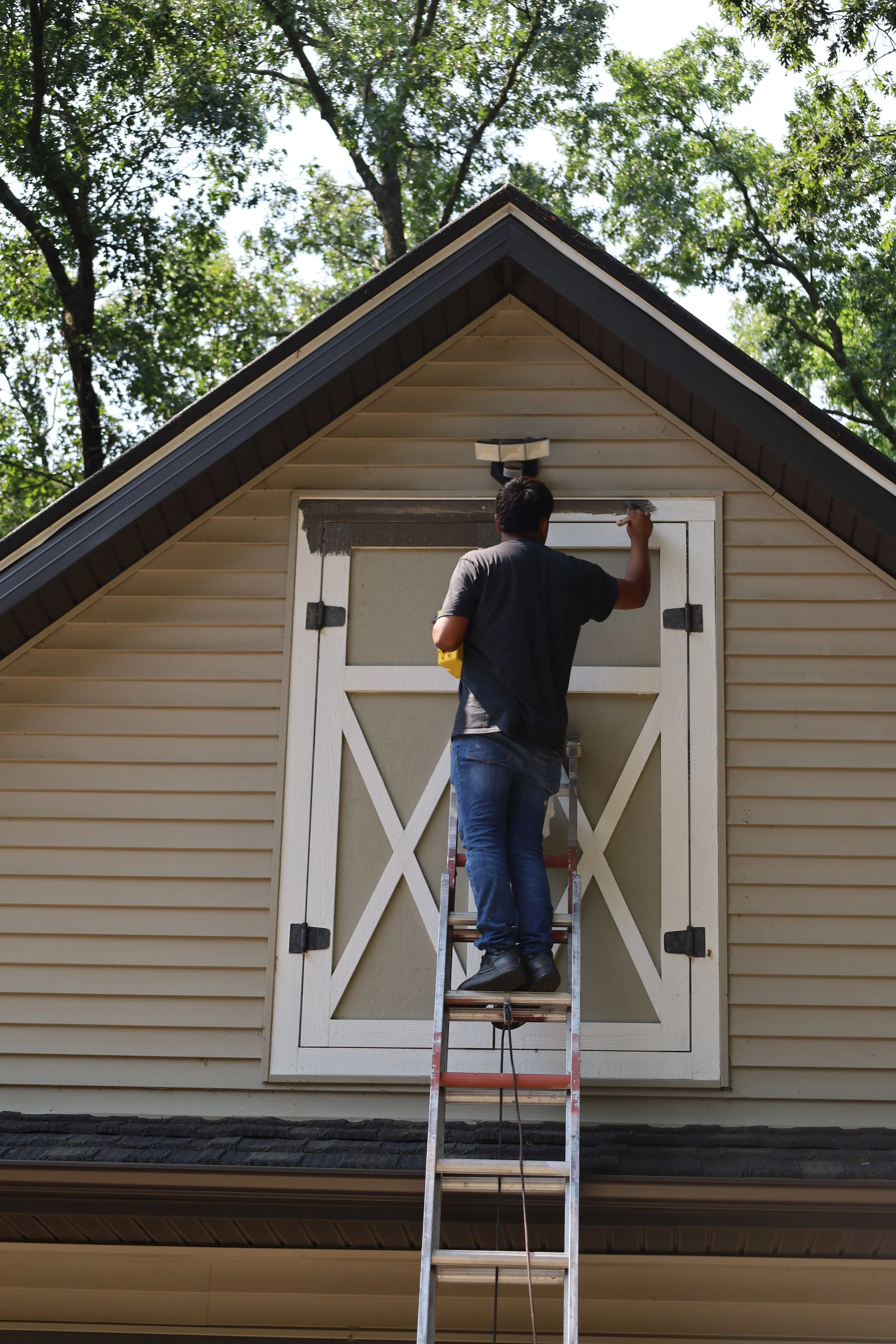Man painting trim of a garage