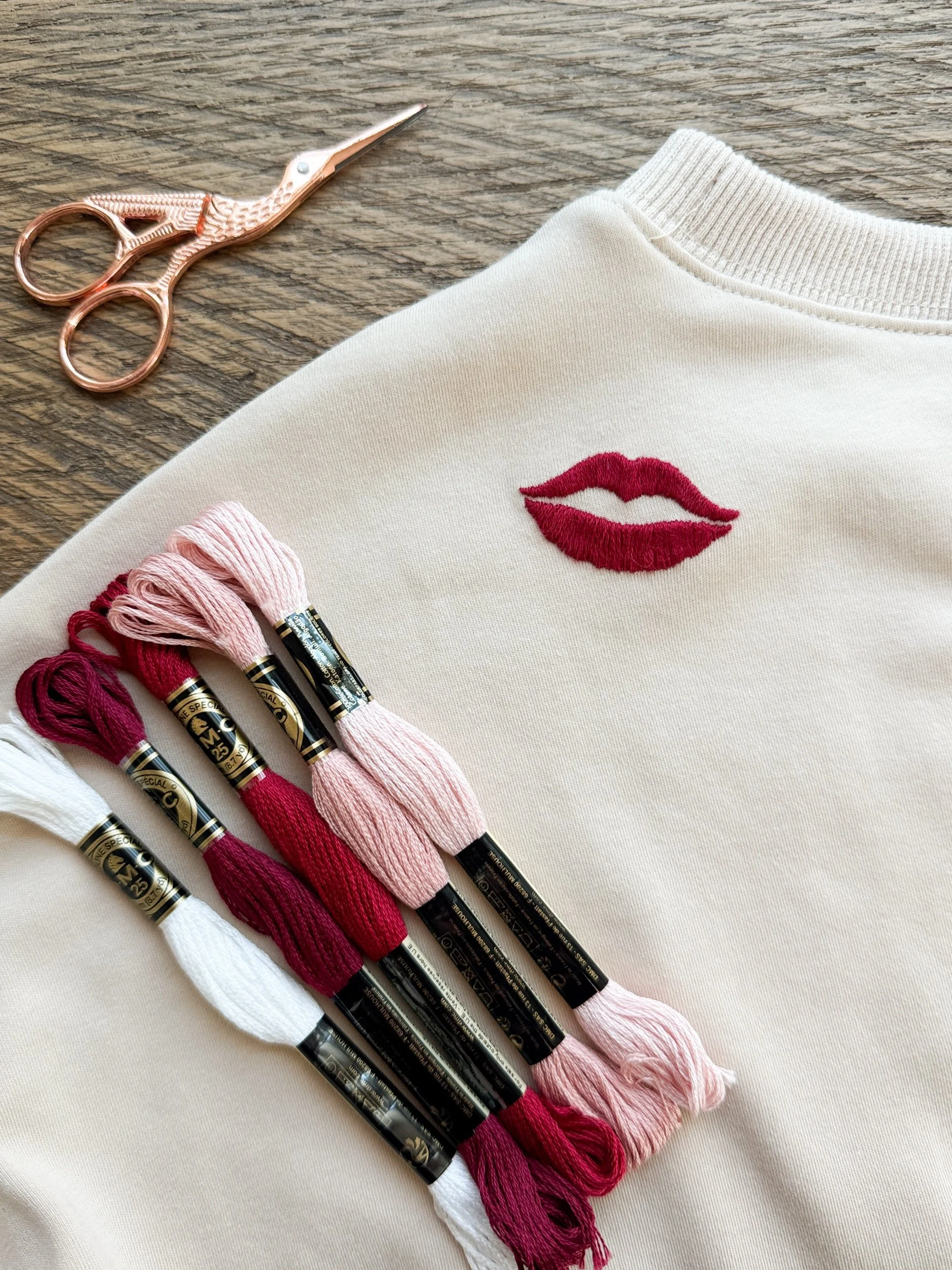 Kiss or Lips hand embroidered on off white crew neck sweatshirt