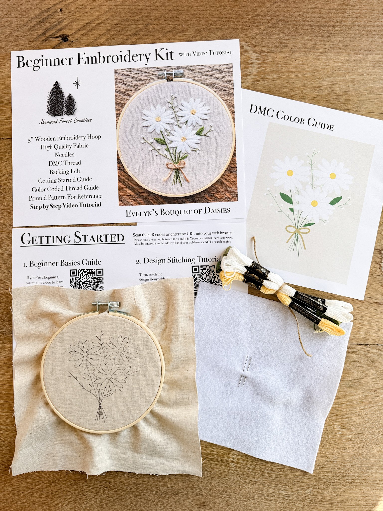 Beginner embroidery kit with a picture of a bouquet of daisies floral embroidery design, embroidery hoop, threads, and embroidery pattern on paper.
