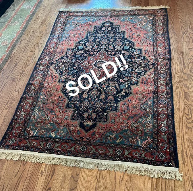 Colorful Persian-style area rug with intricate floral and geometric patterns, sold and placed on a hardwood floor.