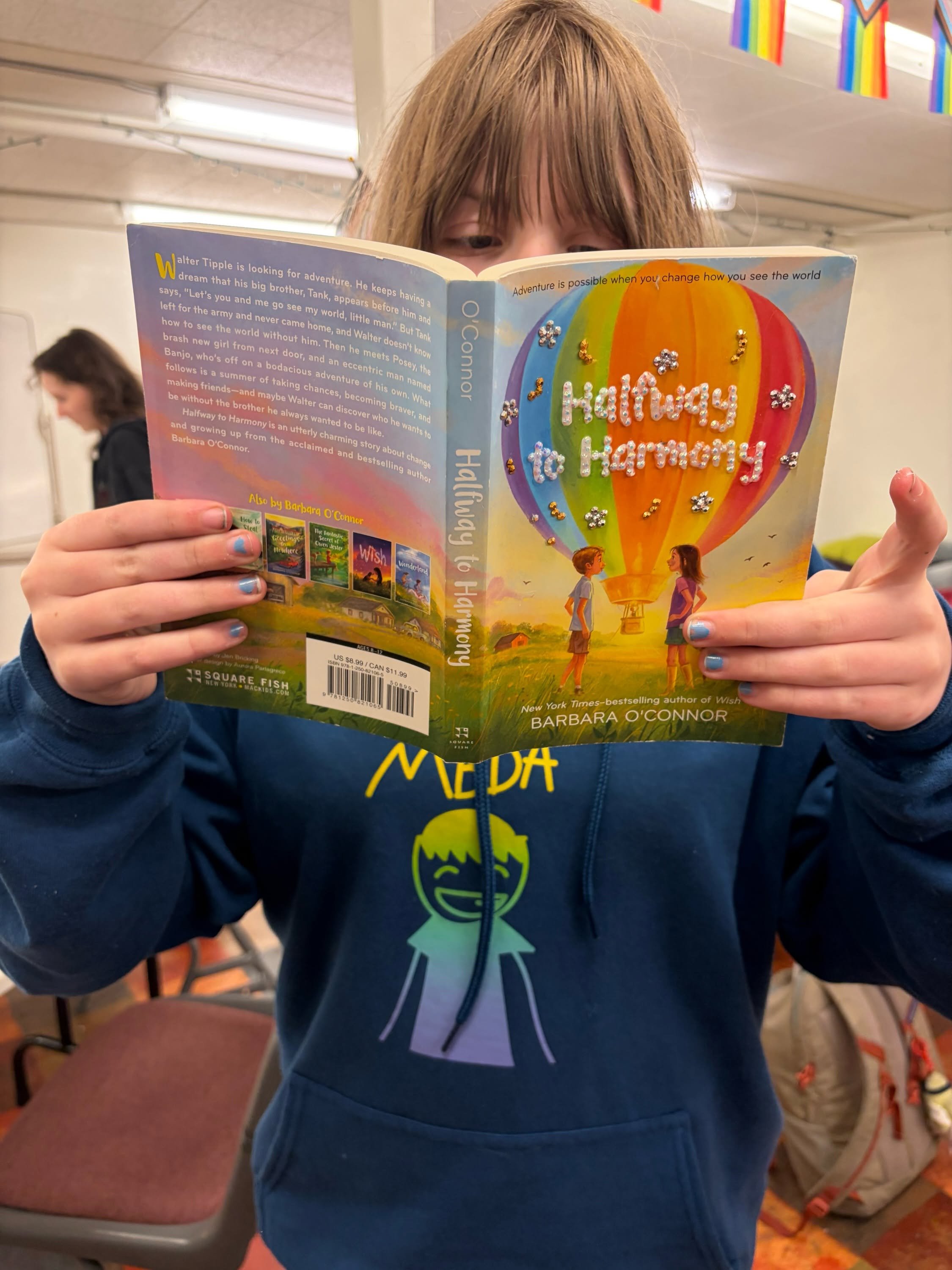 op child reading a book called Halfway Harmony at summer camp
