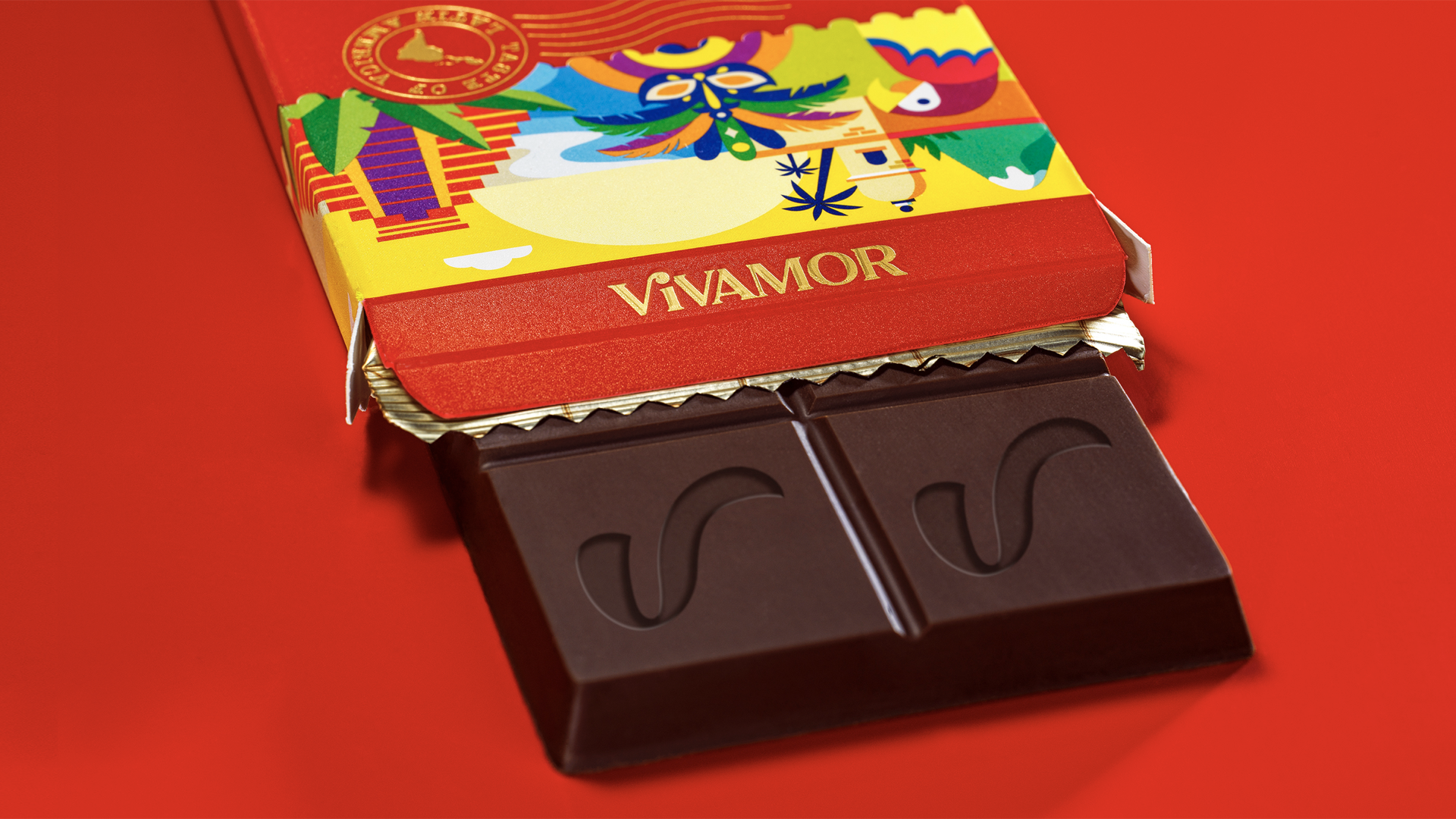 A partially unwrapped Vivamor chocolate bar with a colorful decorative box on a red background.