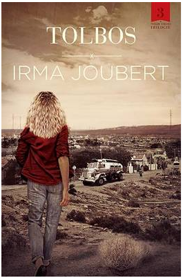 Book cover of 'TOLBOS' by Irma Joubert, featuring a woman with curly blond hair walking away, in a rural landscape with old cars and a dirt road.