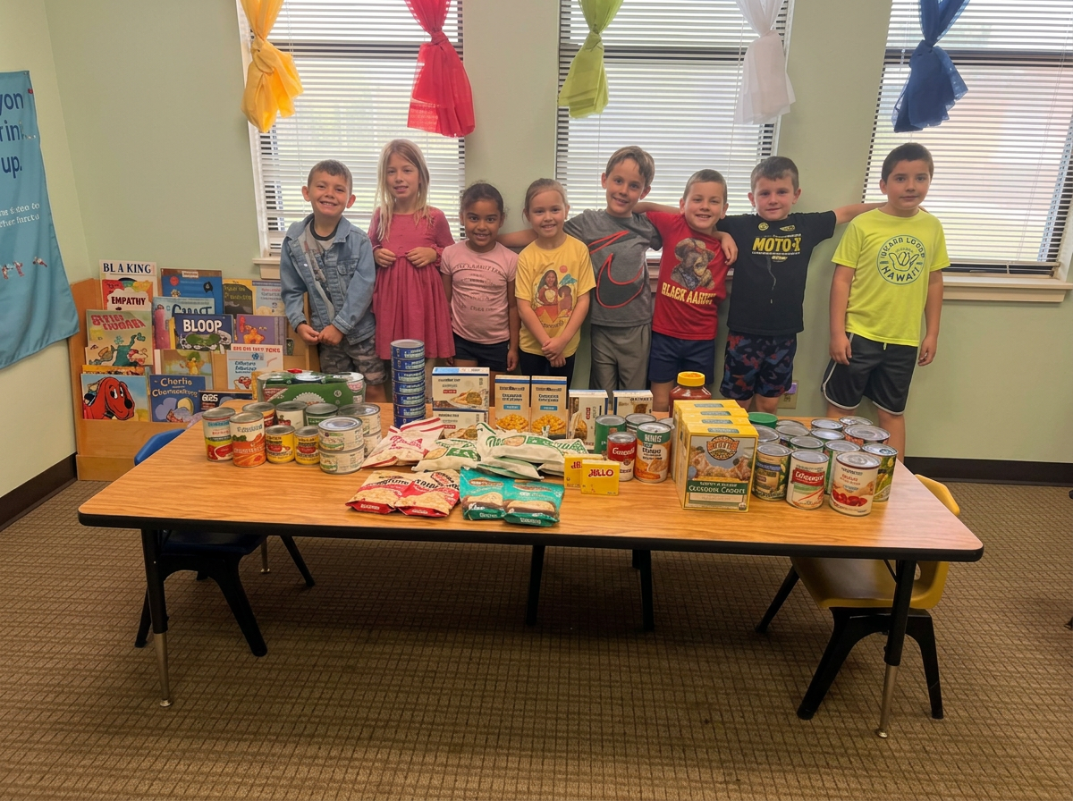 Elementary students stand behind donated food collected for a Raising Arrows Academy community service project.