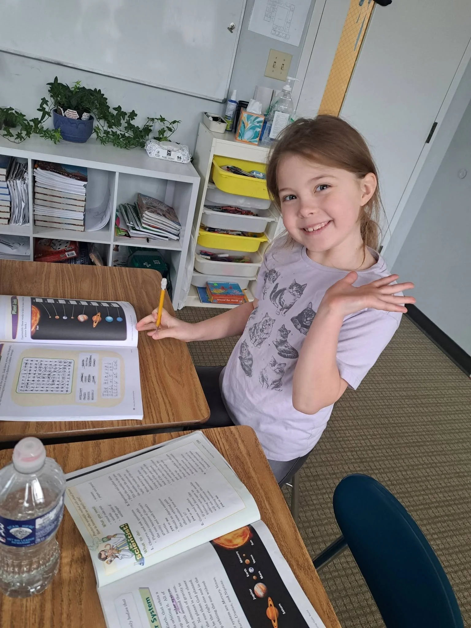 Elementary student smiles while completing a solar system science lesson at Raising Arrows Academy.