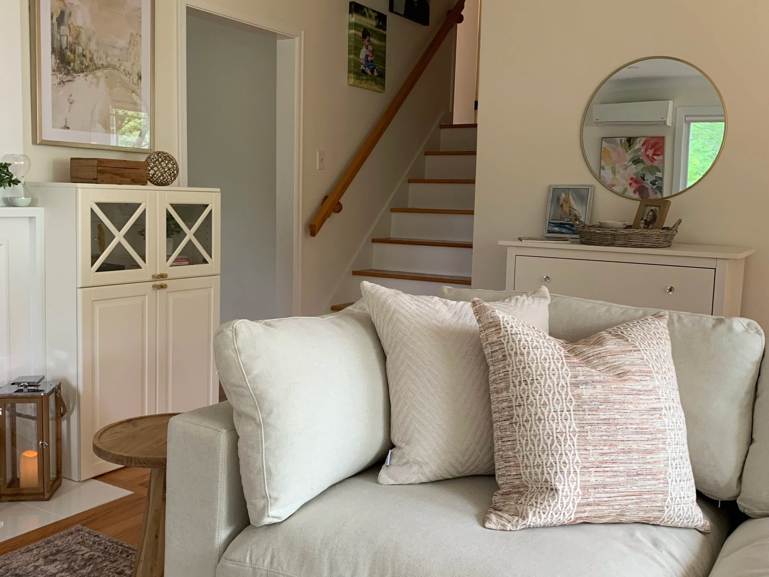 “Comfortable living room with neutral furnishings, layered pillows, decorative accents, and thoughtfully arranged furniture.”