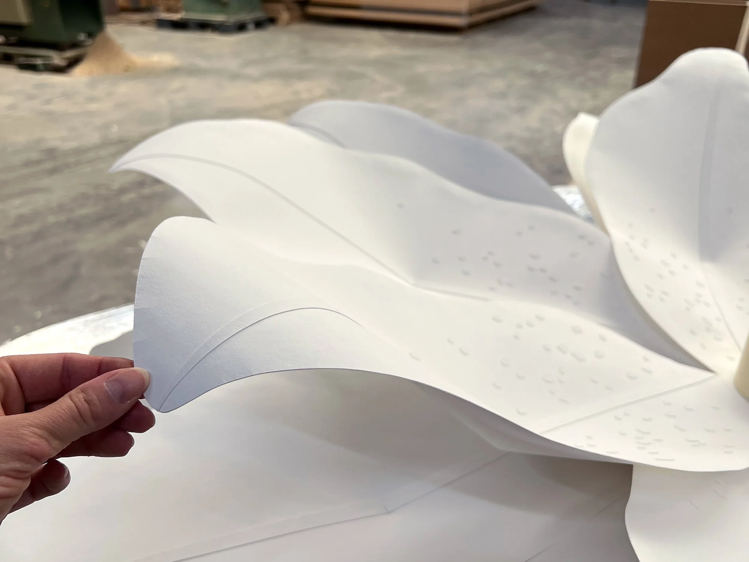 Close-up of handcrafted paper petals showing sculpted curves and embossed surface details.