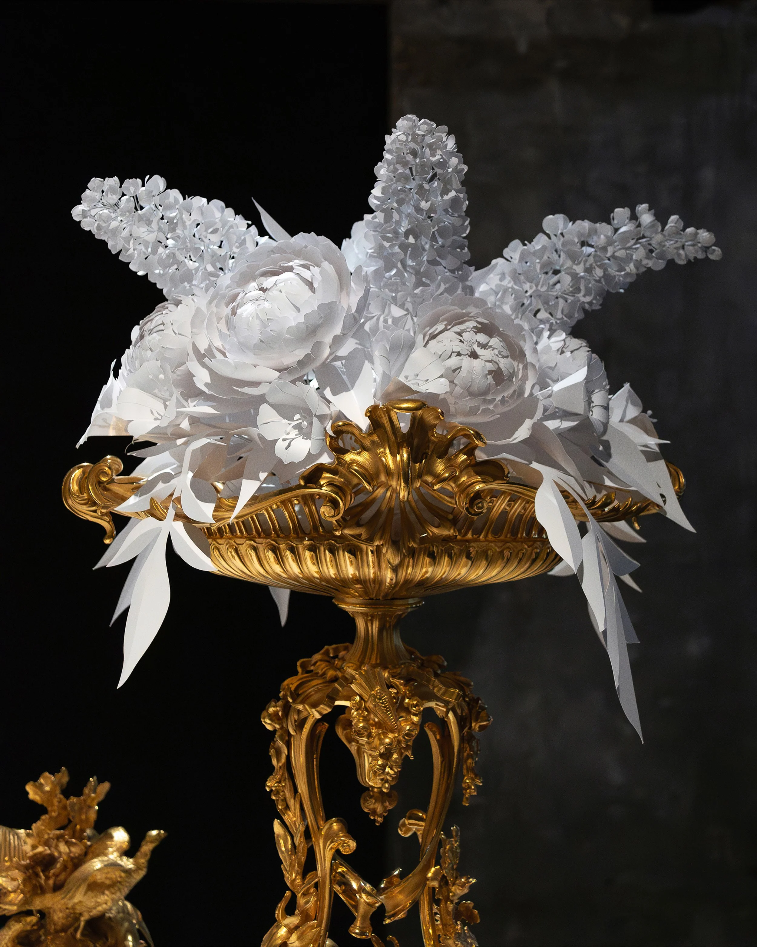 White paper lilac, peonies and bindweed arranged in a gilded Christofle centerpiece, created for the “Christofle, a brilliant story” exhibition at the Musée des Arts Décoratifs, Paris.
