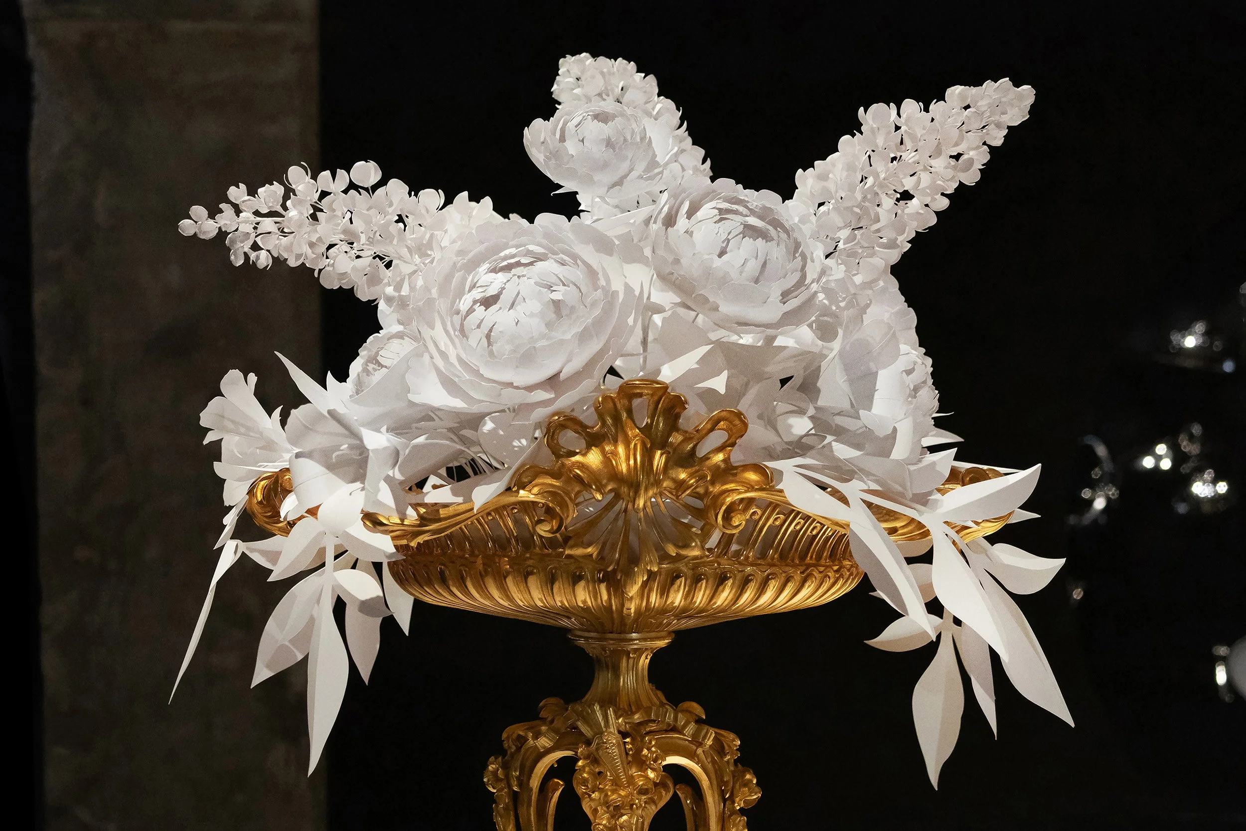 Handcrafted white paper floral arrangement featuring lilac, peonies and bindweed displayed in a gilded Christofle basket at the Musée des Arts Décoratifs, Paris.