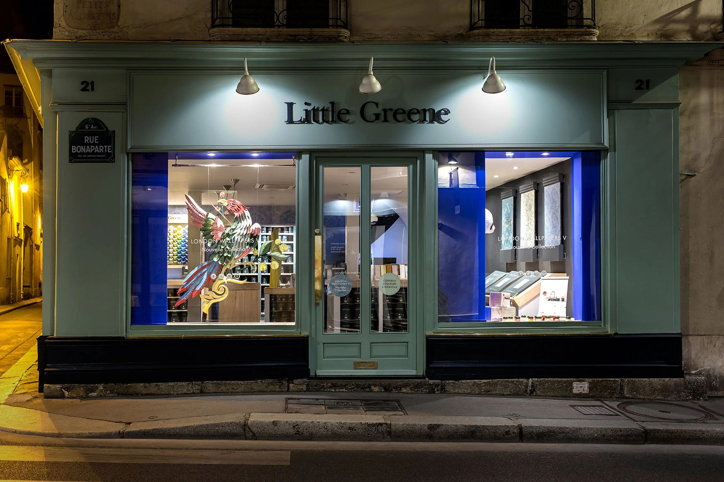 Little Greene showroom facade at night with Bird of Paradise window display, Paris