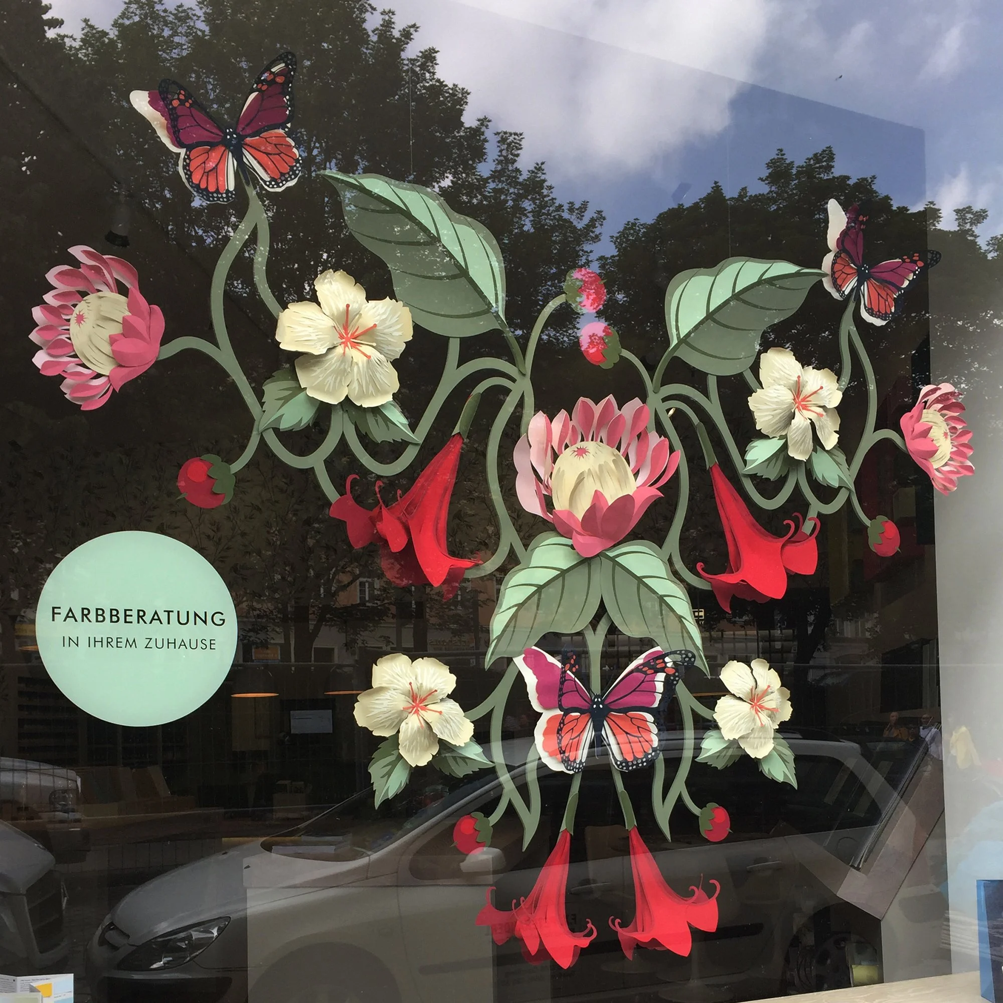 Detail of a paper floral window display inspired by the Asterid wallpaper pattern, installed in the Little Greene Munich showroom