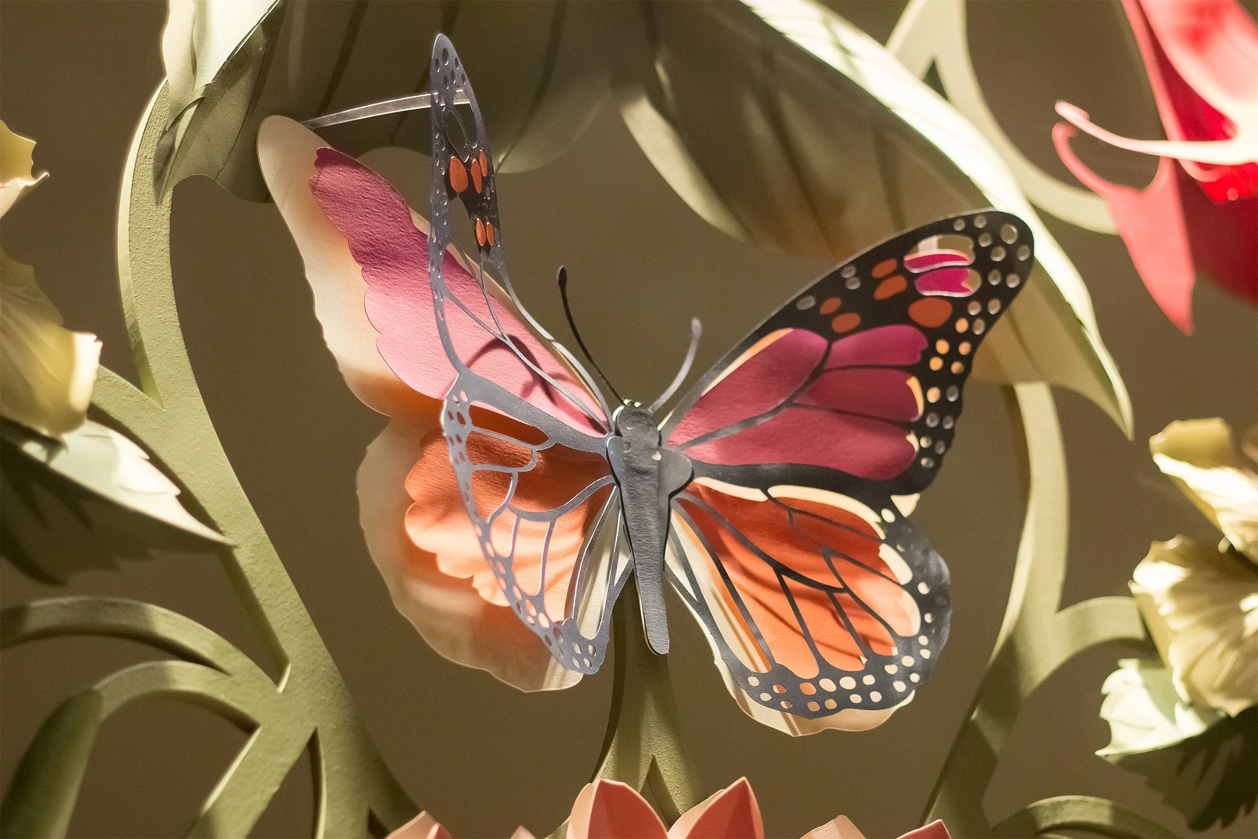 Hand-painted paper butterfly integrated into a floral installation inspired by Little Greene's Asterid wallpaper pattern