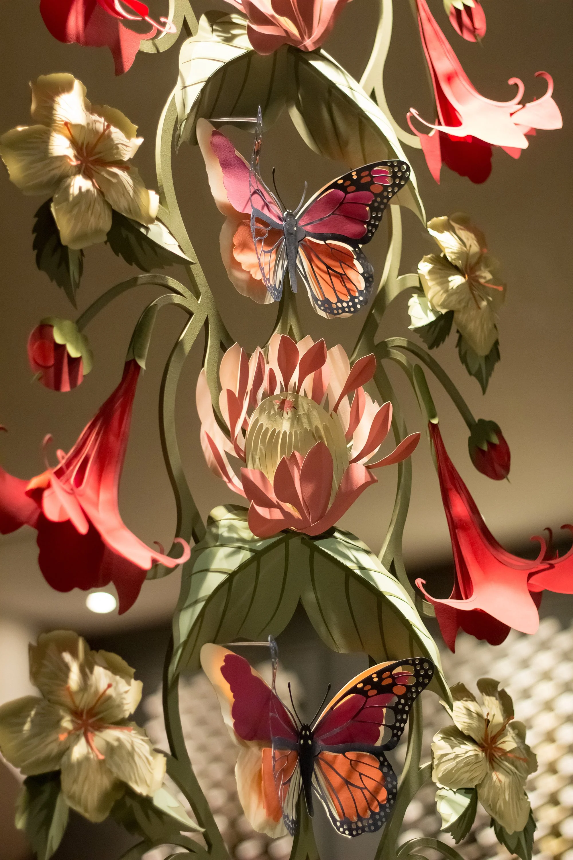 Detail of handcrafted paper flowers and butterflies inspired by the Asterid wallpaper pattern