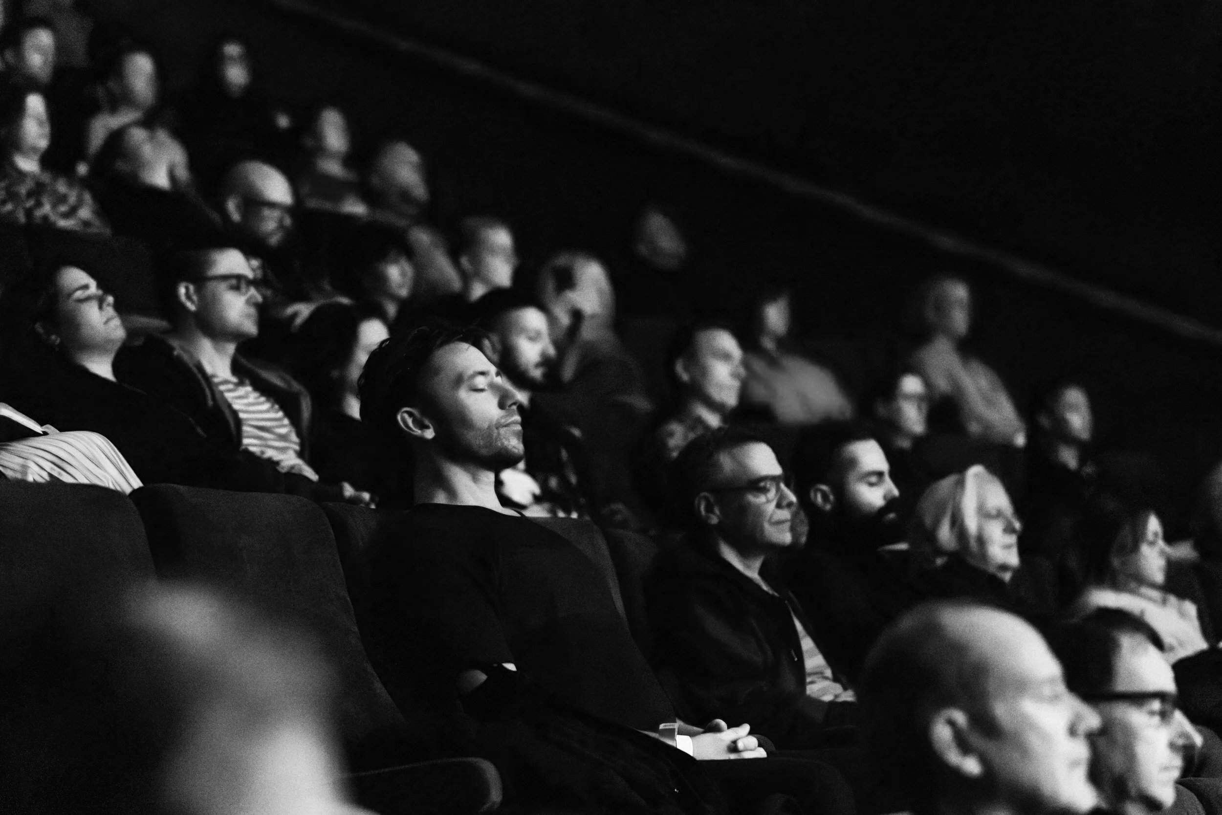 People sitting attentively in a dimly lit theater