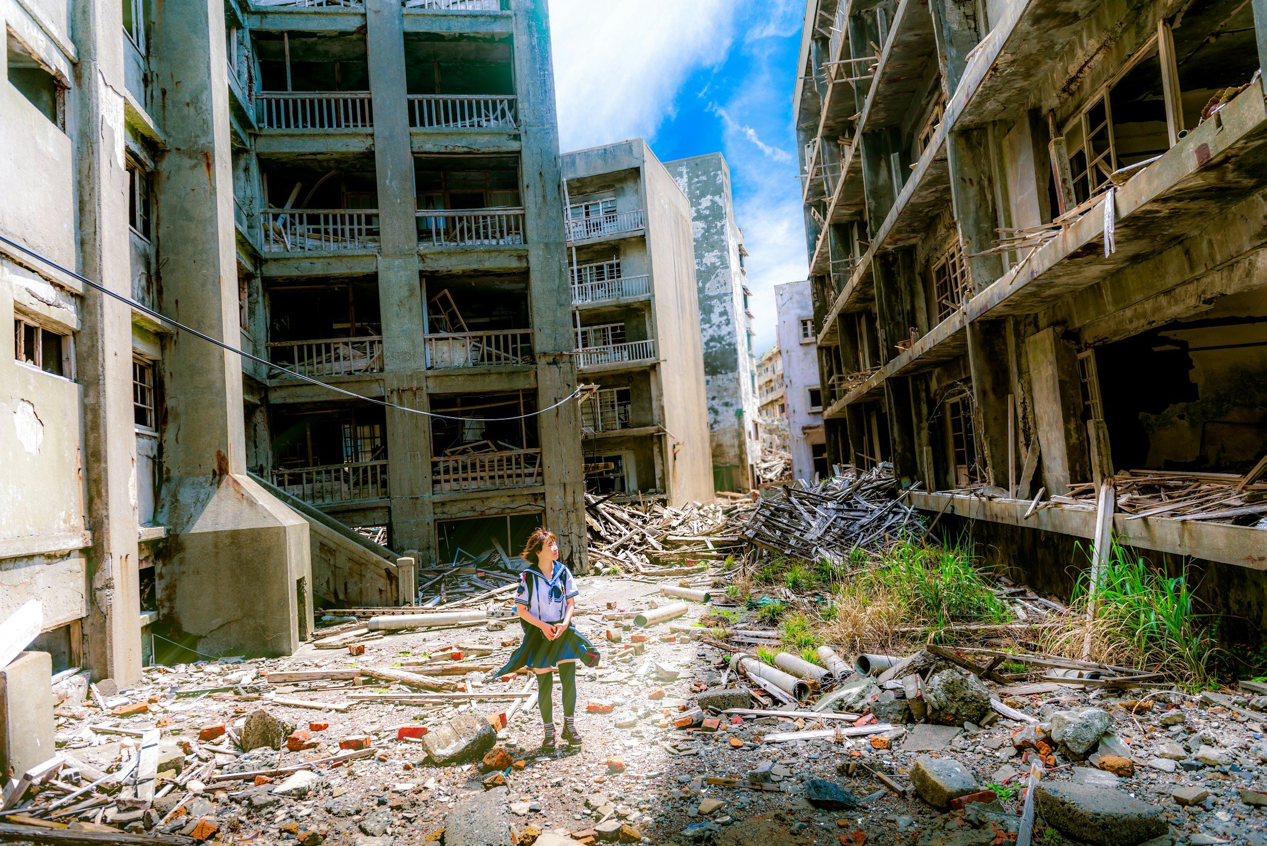 teenage girl walks through neighborhood of apartments decimated by natural disaster