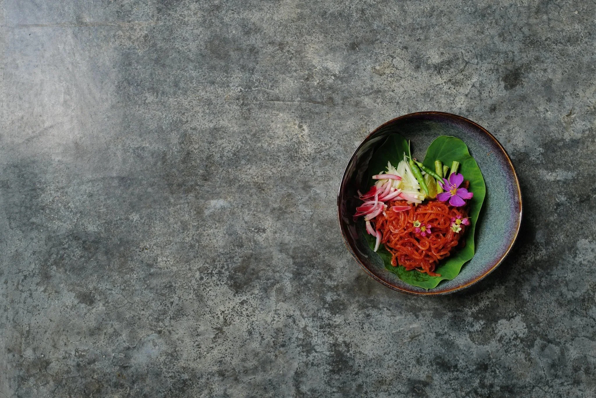 Authentic Thai noodle salad with herbs and edible flowers.