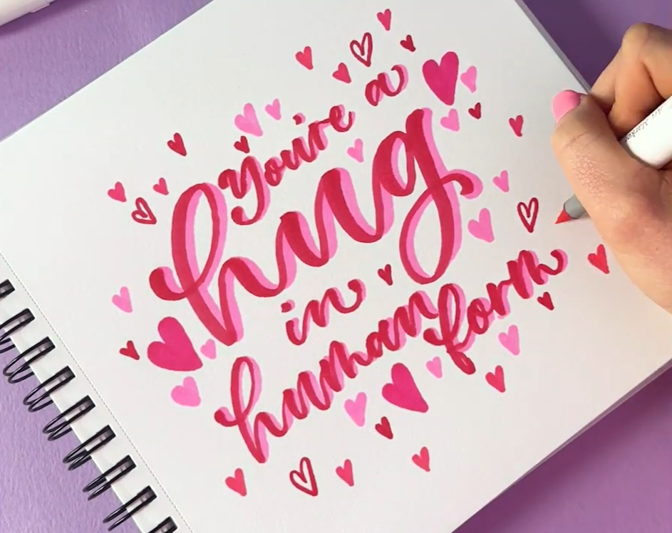 A finished calligraphy art piece in contrasting pink and red created with Ohuhu markers to celebrate Galentine's Day