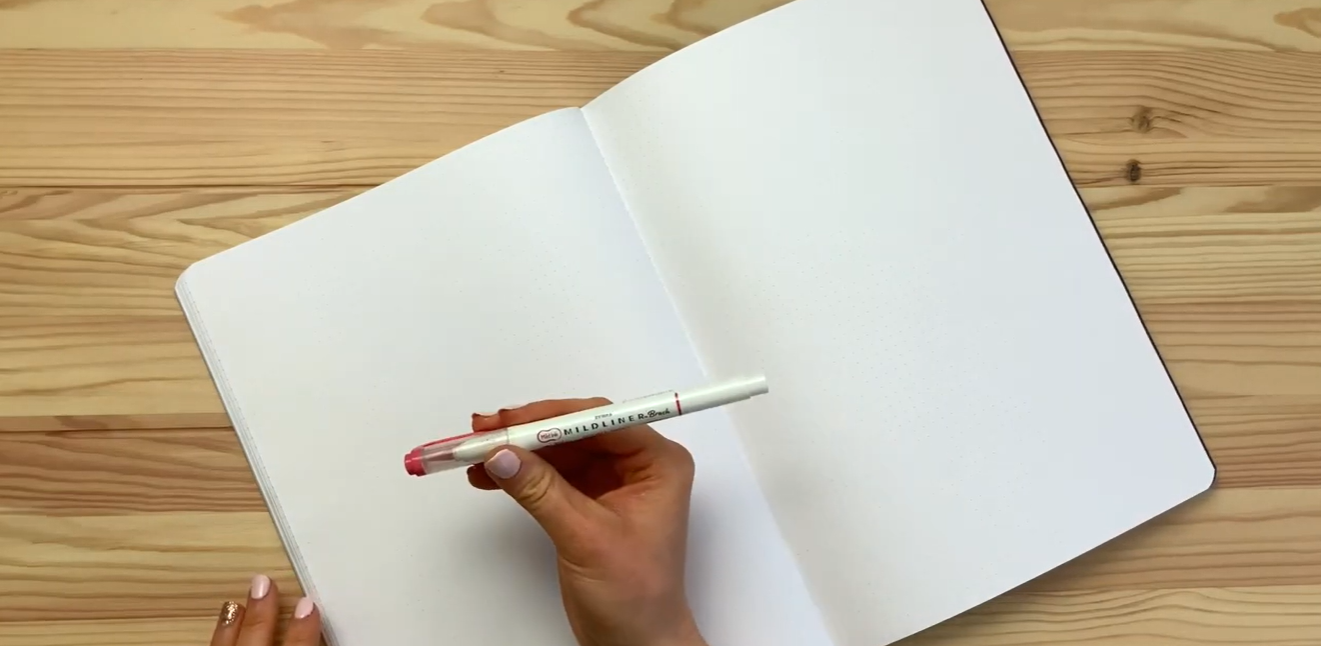 Brush pen and dot grid notebook set up for a calligraphy lesson