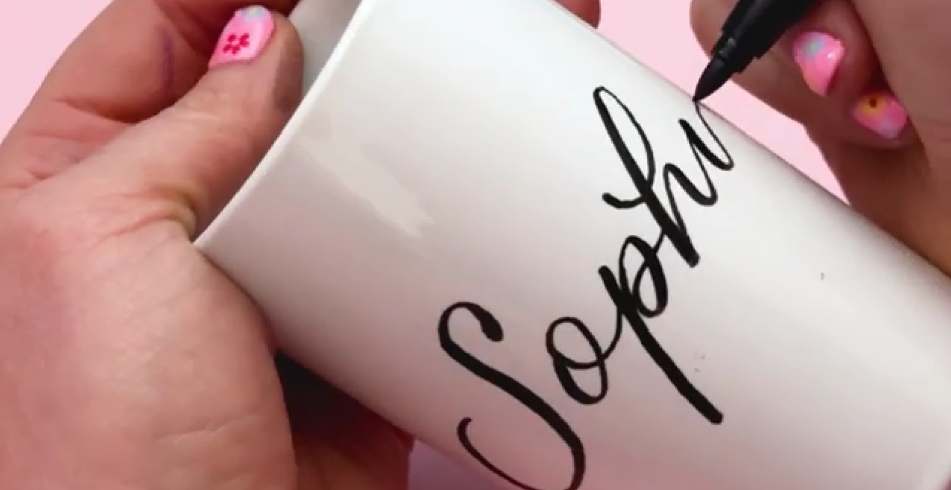 Adding black calligraphy lettering to ceramic pen pot using porcelain brush pen on curved surface