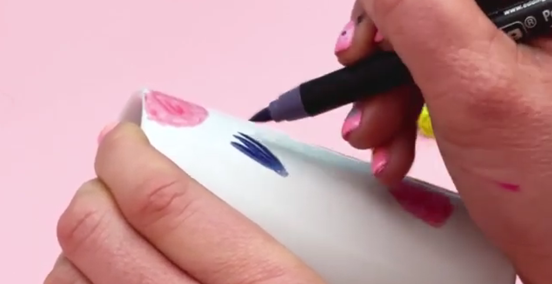 Adding textured five petal purple flowers to ceramic pen pot design using brush pen strokes