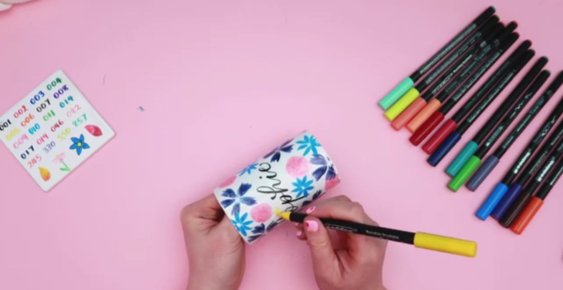 Painting small yellow five petal flowers to fill gaps in floral ceramic design