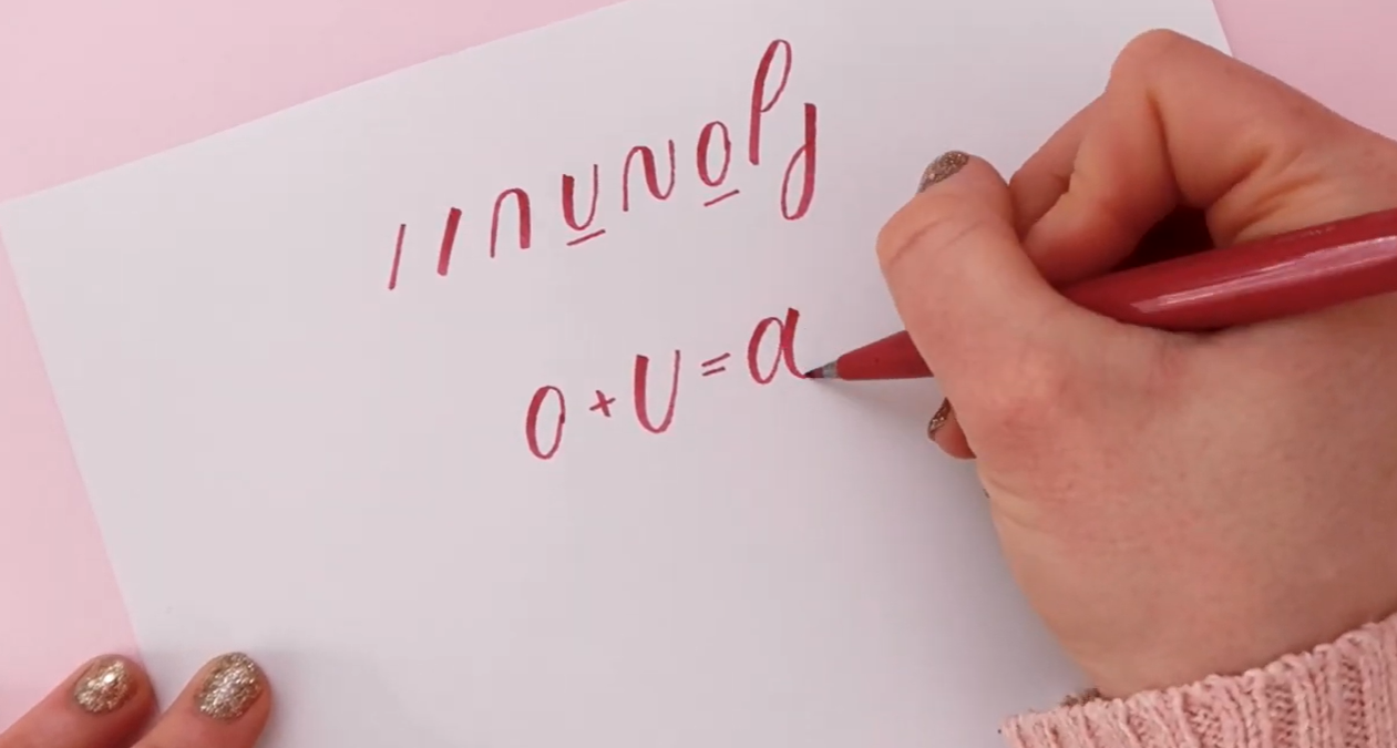 A brush pen working through a series of calligraphy drill shapes on dotted paper, showing the repetitive squiggly strokes used to build muscle memory for lettering.