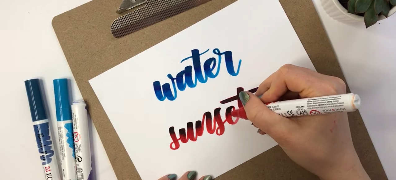 Contrasting scarlet and violet blend: "Hand-lettered calligraphy blending bold scarlet and ultramarine violet Ecoline brush pen colours, demonstrating how to blend two highly contrasting shades.”