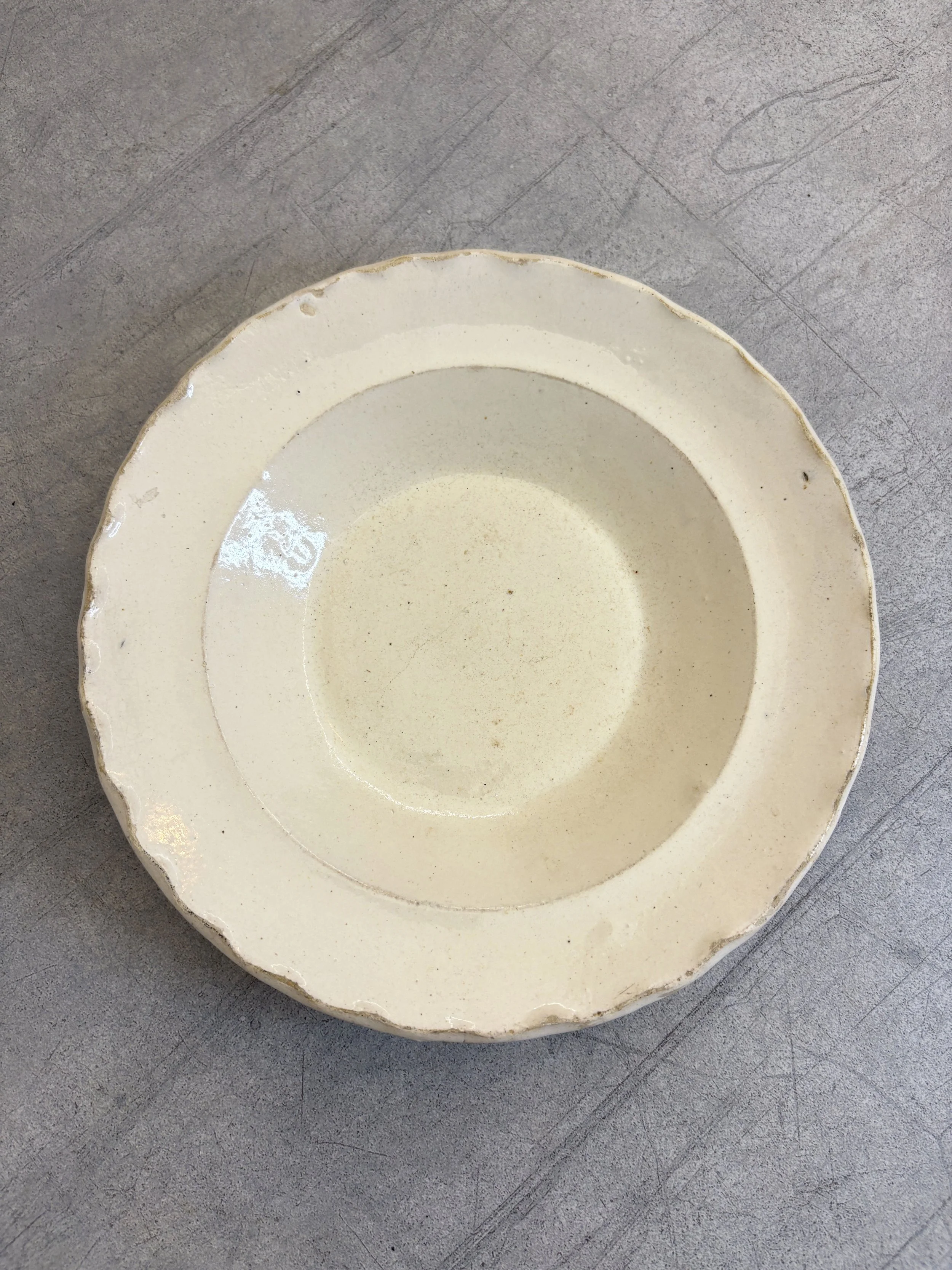 cream glazed ceramic plate with scalloped edge