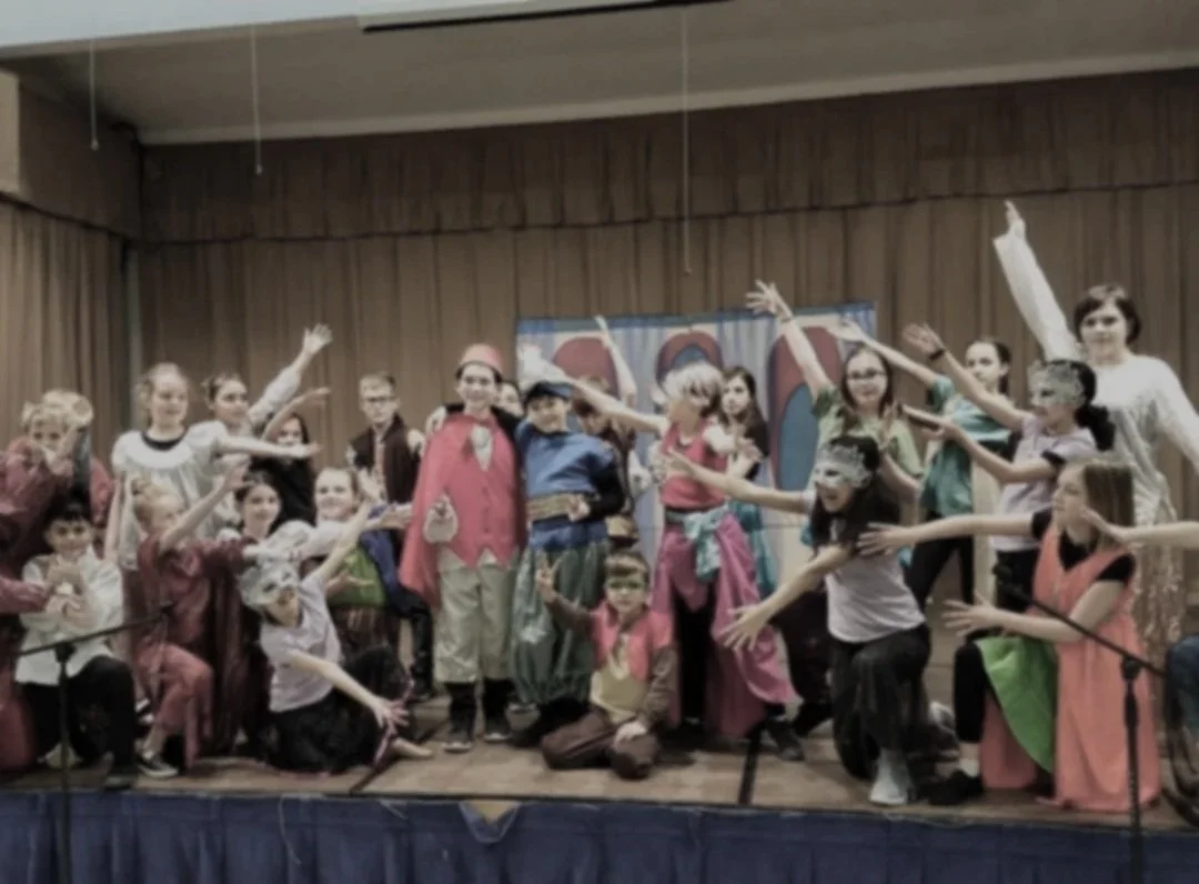 Children in an ending pose from a musical