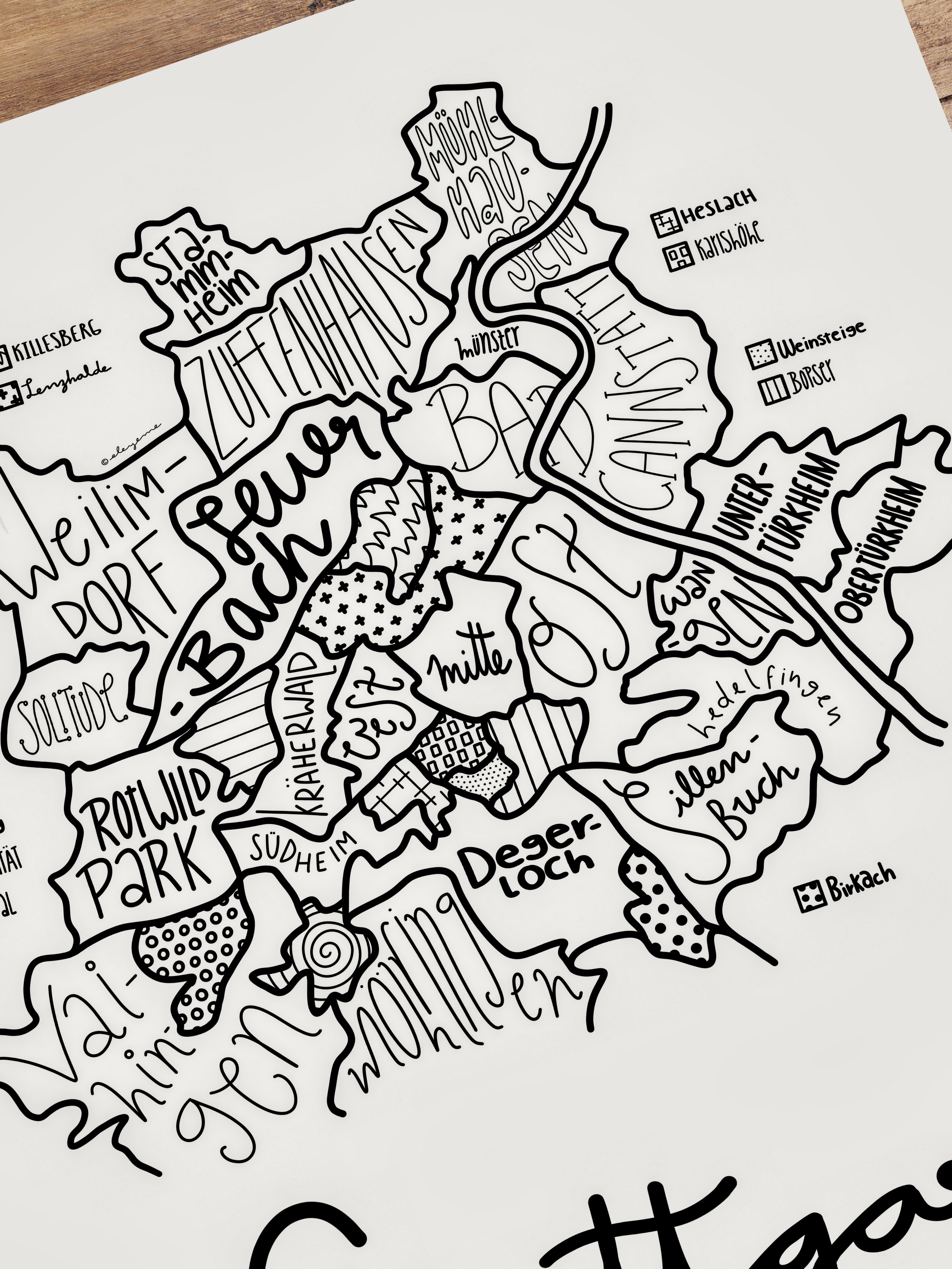 Close-up of an unframed illustrated map of Stuttgart resting on a table.