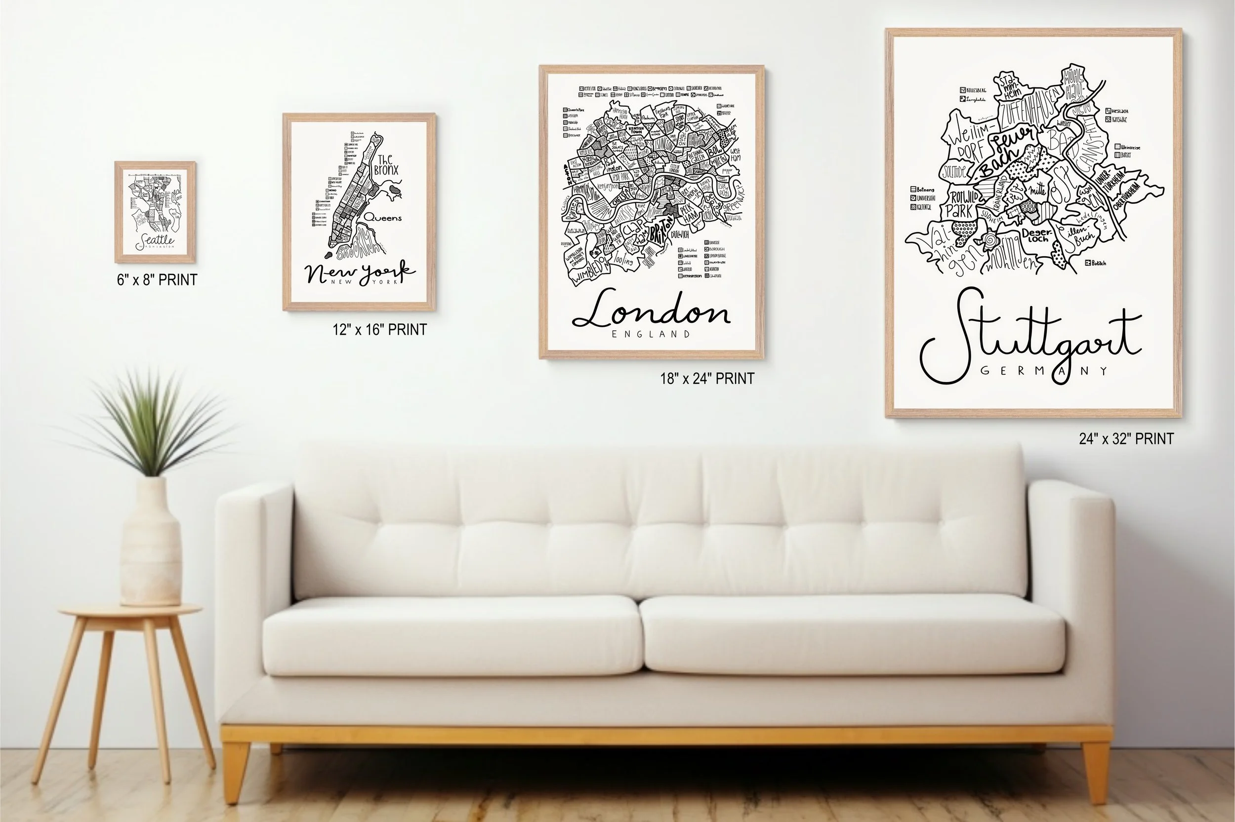 Natural wood framed illustrated map of Stuttgart displayed above a living room couch alongside other map prints.