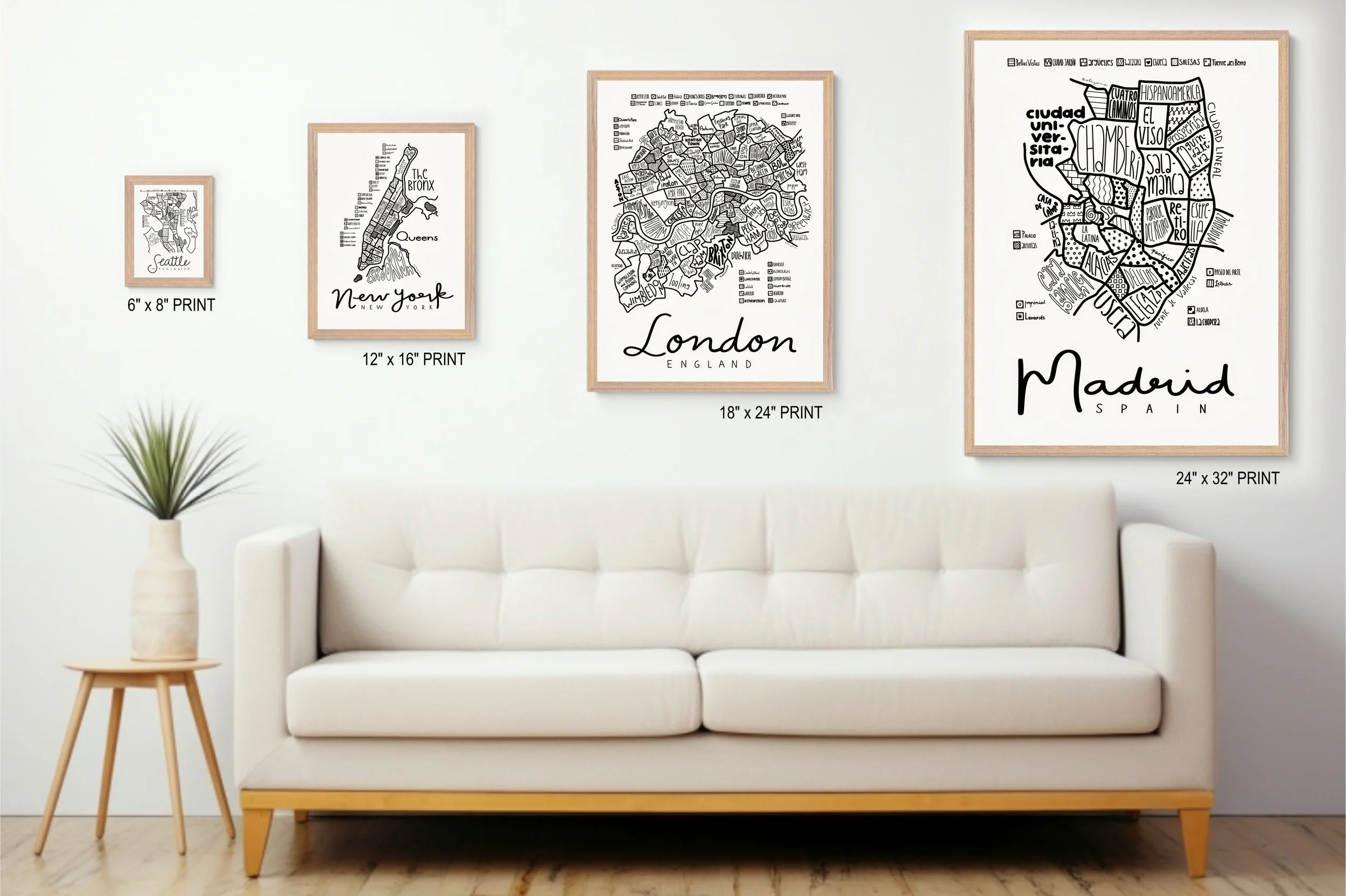 Natural wood framed illustrated map of Madrid displayed above a living room couch alongside other map prints.