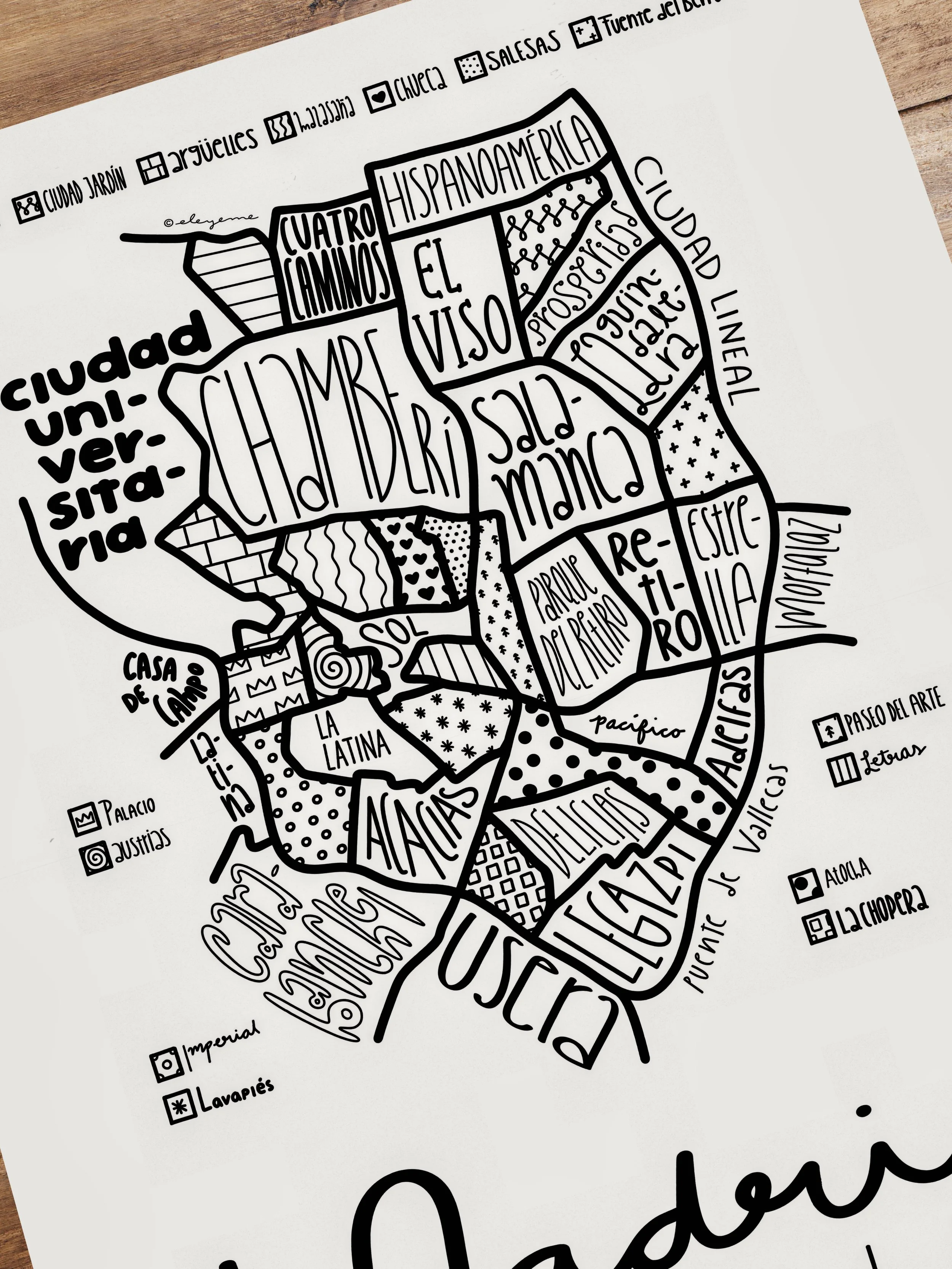 Close-up of an unframed illustrated map of Madrid resting on a table.
