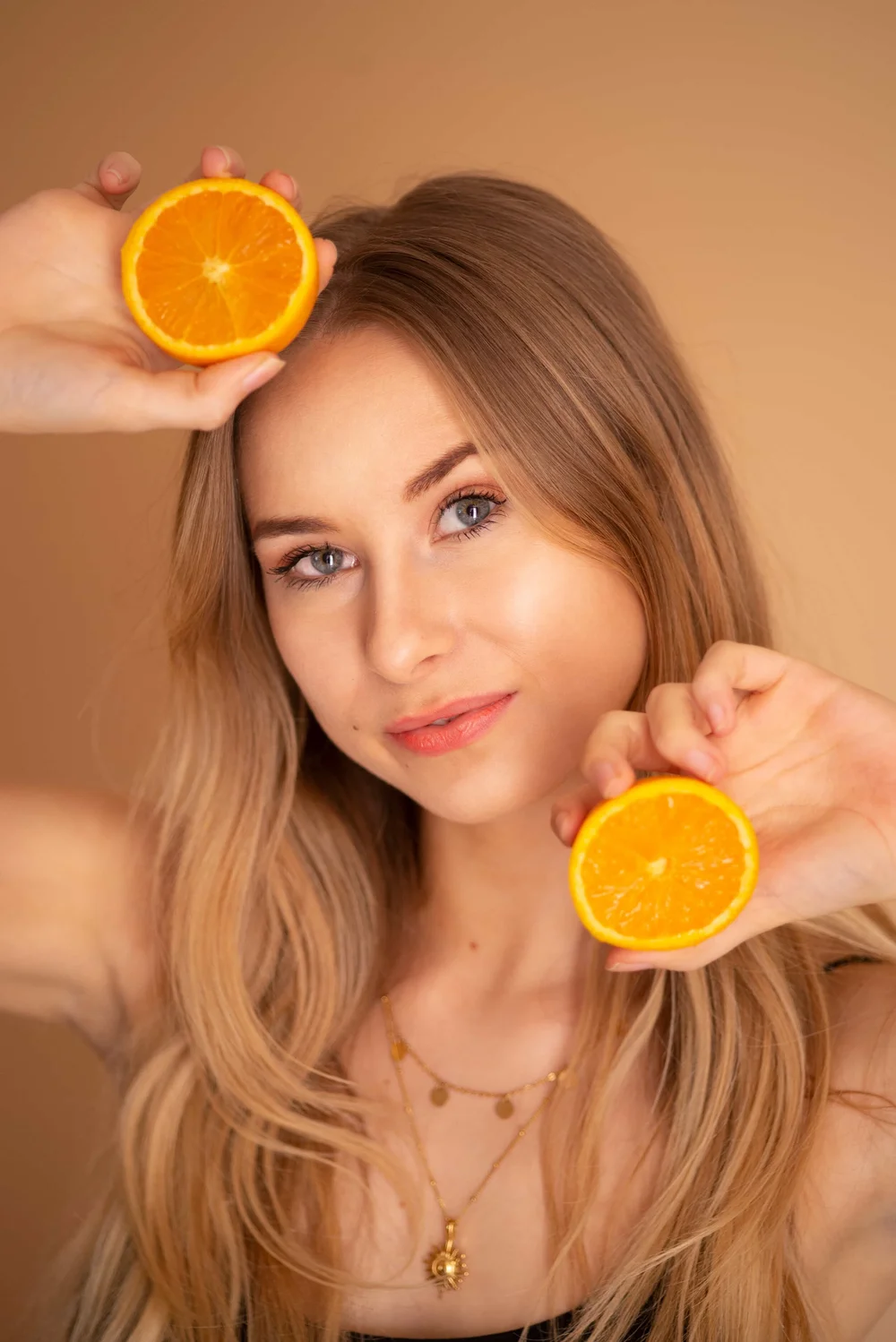 Portrait femme aux  yeux bleus tenant des oranges