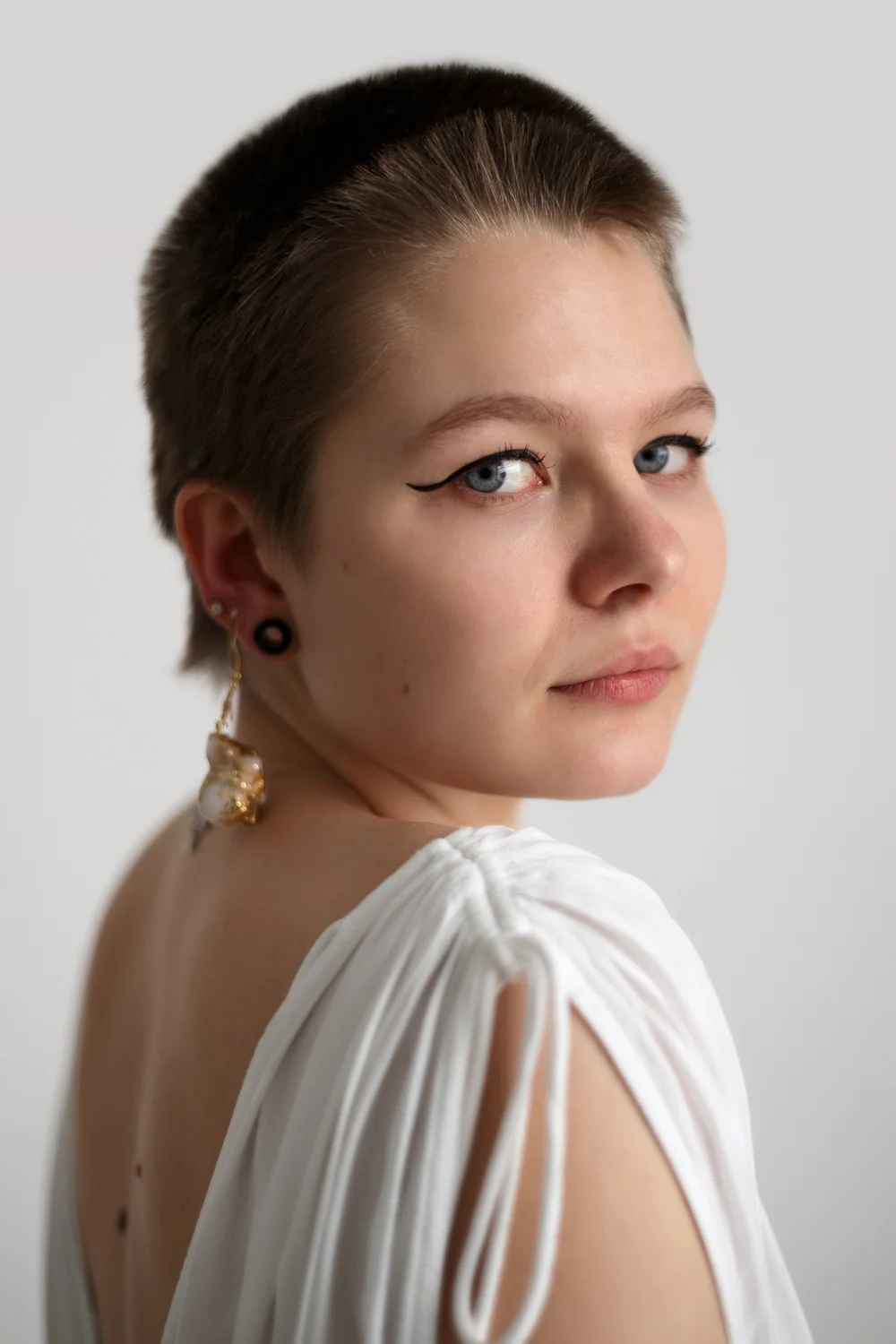 portrait jeune femme cheveux rasés yeux bleus