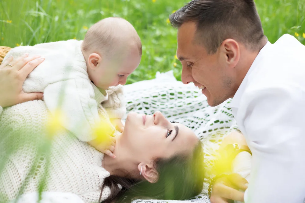 parents et bébé allongés dans l'herbe