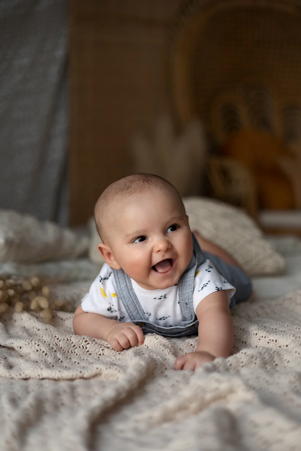 Bébé riant allongé sur le ventre en studio.