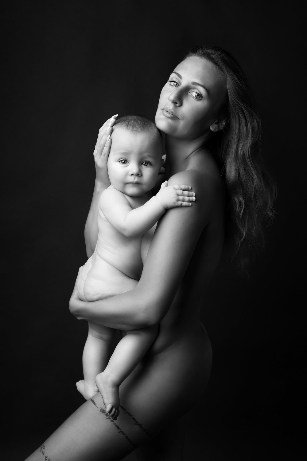 Maman tenant son bébé contre elle, en noir et blanc.
