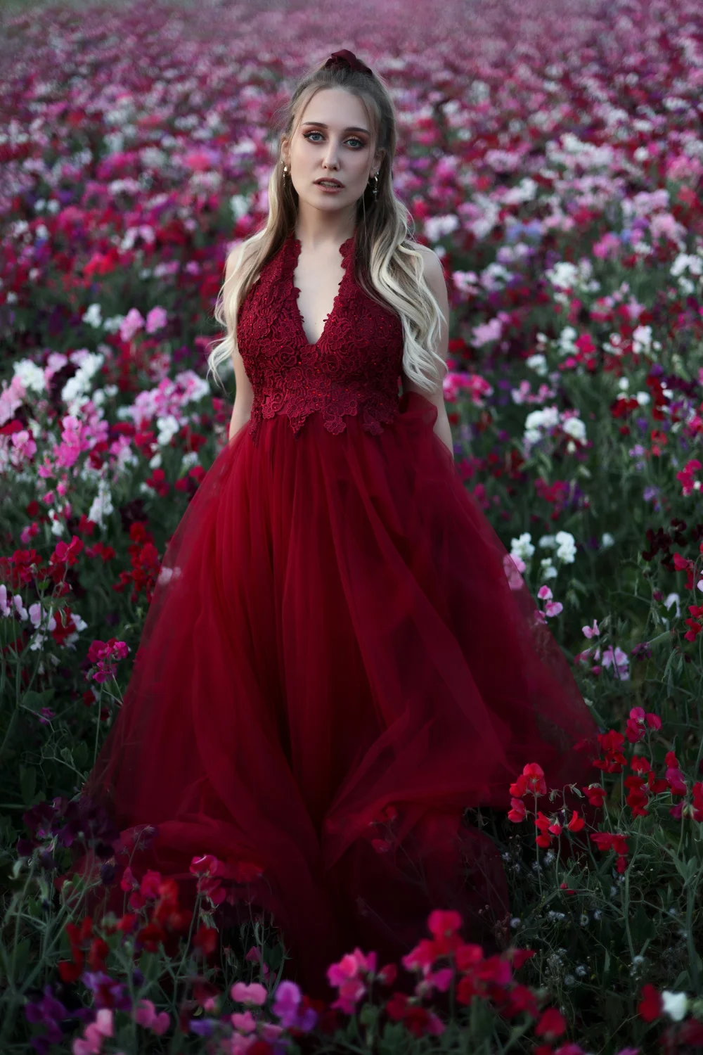 blonde cheveux longs robe de princesse dans un champ de fleurs roses