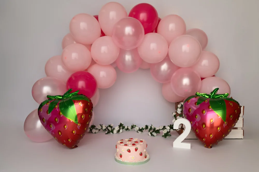 Arche de ballons roses avec des fraises et un chiffre 2.