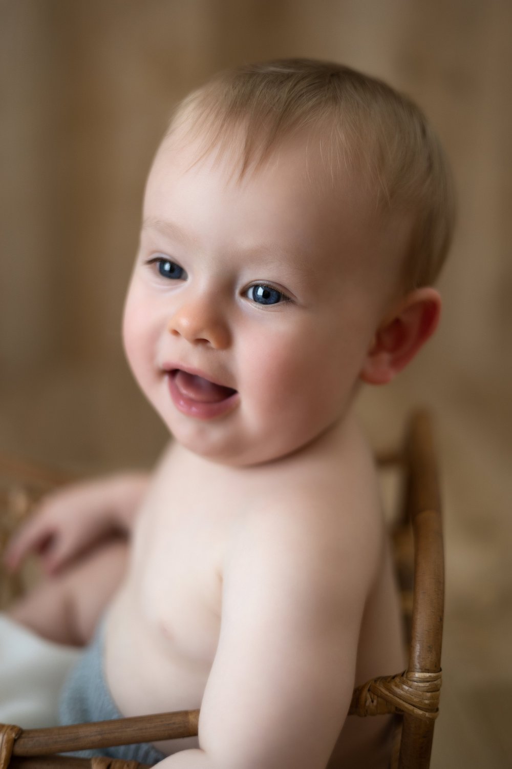 Bébé souriant assis dans un fauteuil, gros plan.
