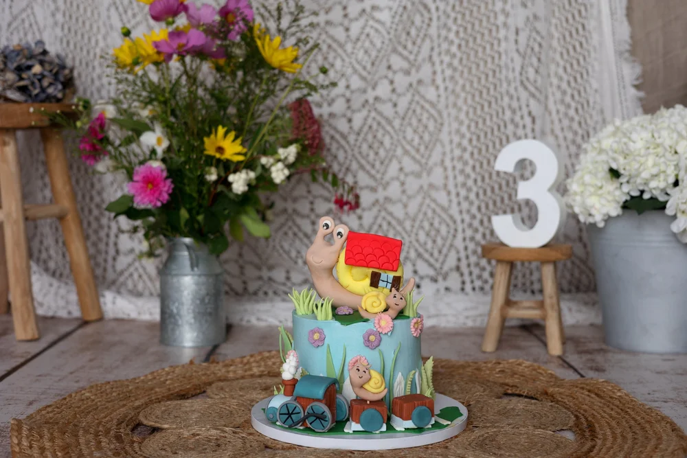 Gâteau d’anniversaire coloré avec un chiffre 3 et un bouquet de fleurs.