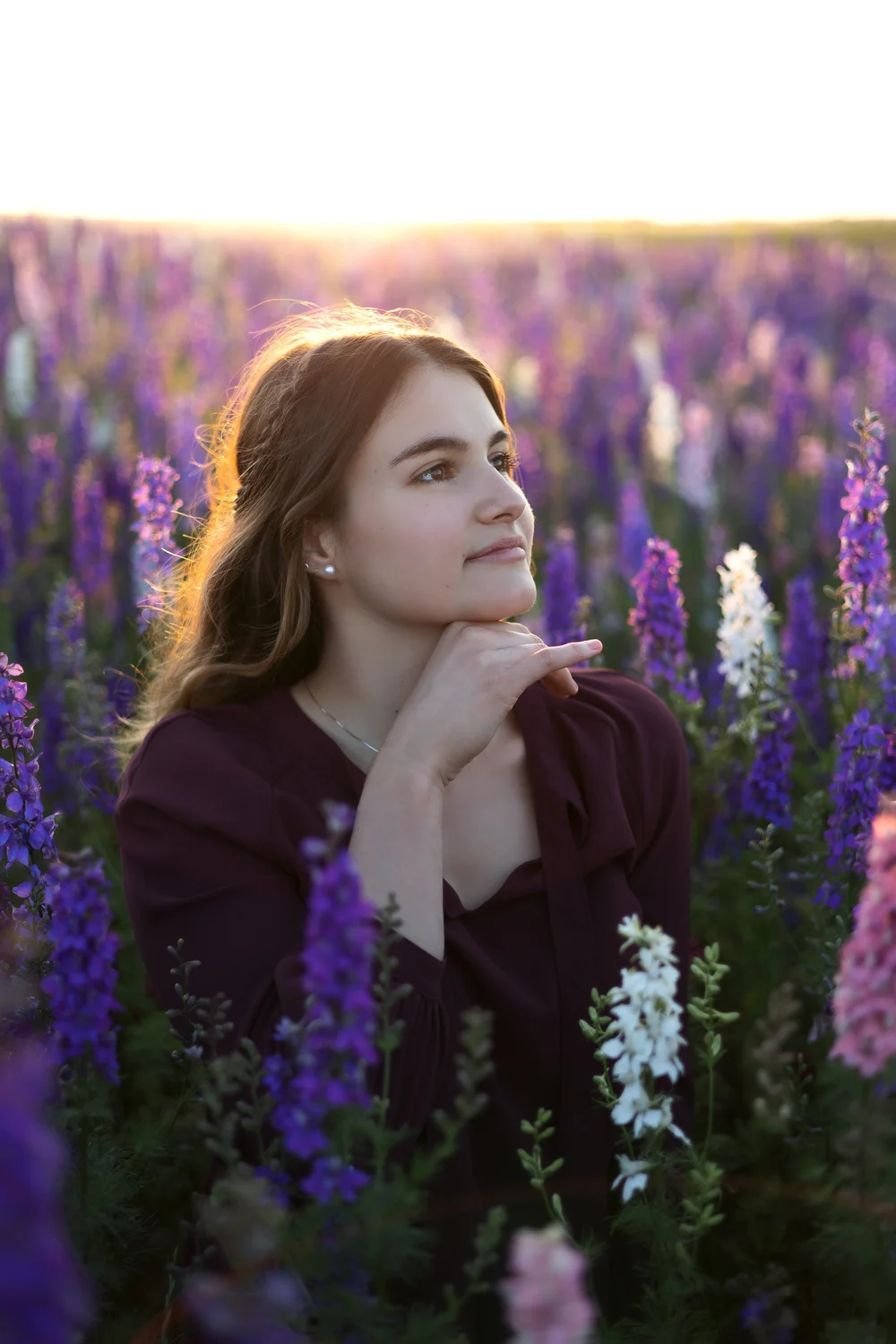 Femme en robe violette dans un champ de fleurs violettes.